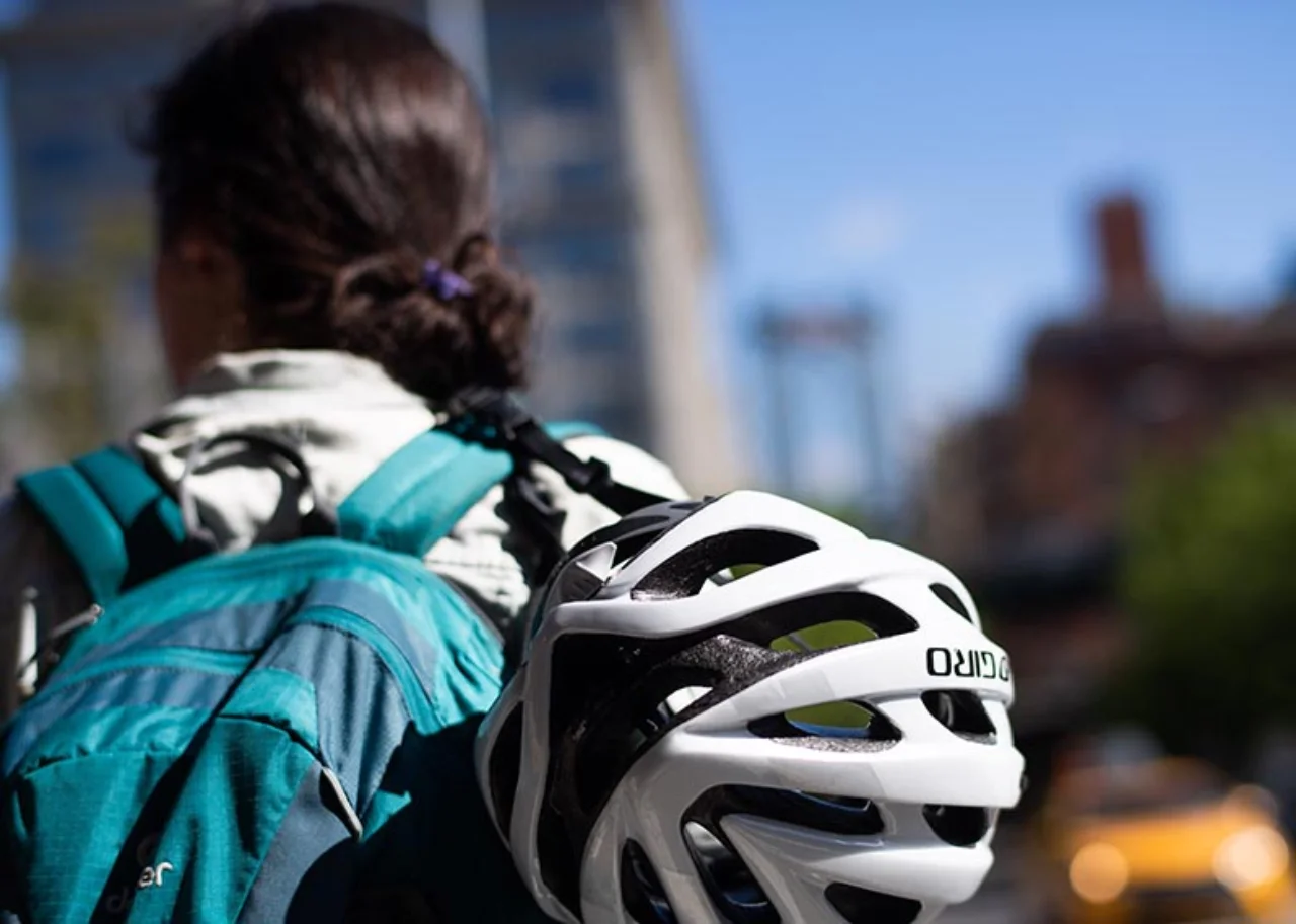 Frau mit Rucksack und Fahrradhelm, von hinten zu sehen
