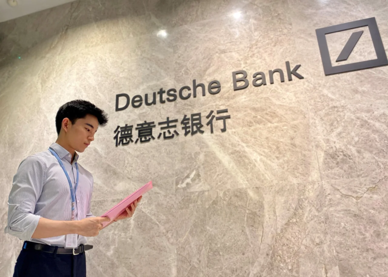 Sean vor einer Wand mit Deutsche Bank China Logo